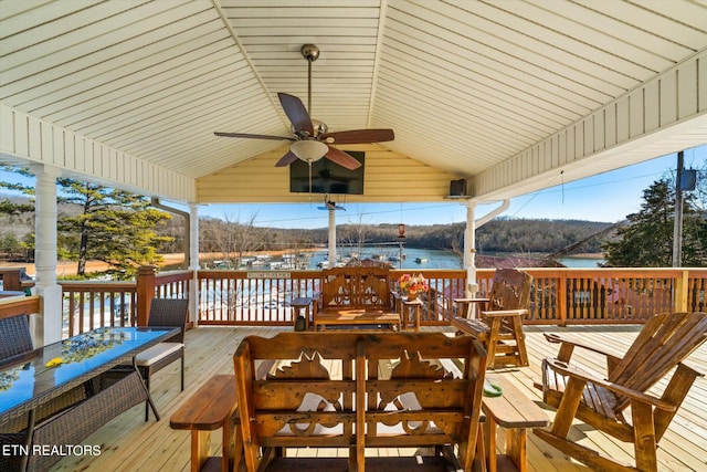 deck with a water view and ceiling fan