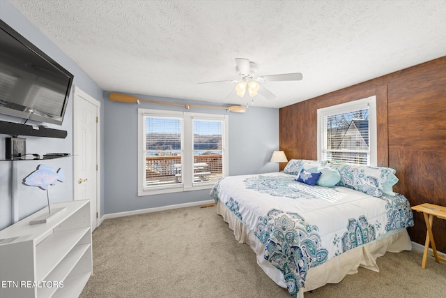 bedroom featuring multiple windows, a textured ceiling, light carpet, and ceiling fan