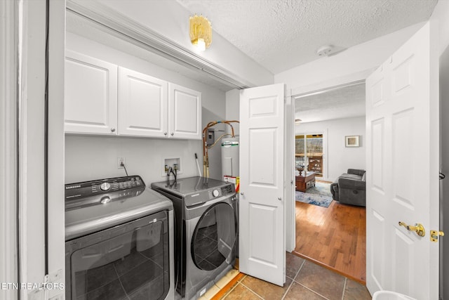 laundry area featuring a textured ceiling, washer hookup, washing machine and dryer, and wood-type flooring