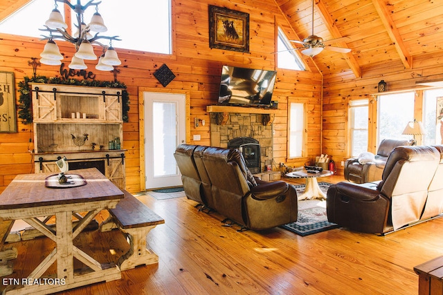 living room with wood ceiling, a wealth of natural light, hardwood / wood-style flooring, and wood walls