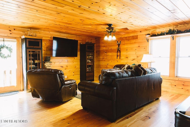 living room featuring wood ceiling, ceiling fan, wooden walls, and light hardwood / wood-style floors