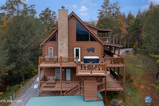 back of house with a hot tub, a wooden deck, and cooling unit