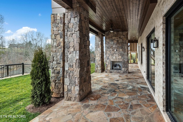 view of terrace featuring an outdoor stone fireplace