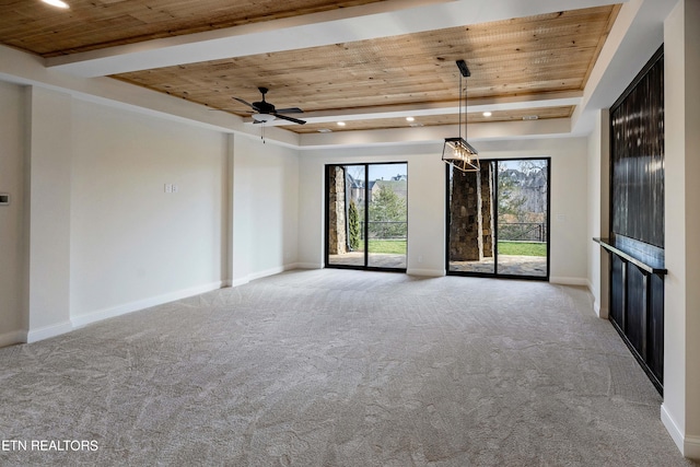 empty room with a tray ceiling, wooden ceiling, and ceiling fan