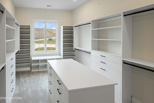 walk in closet featuring light colored carpet