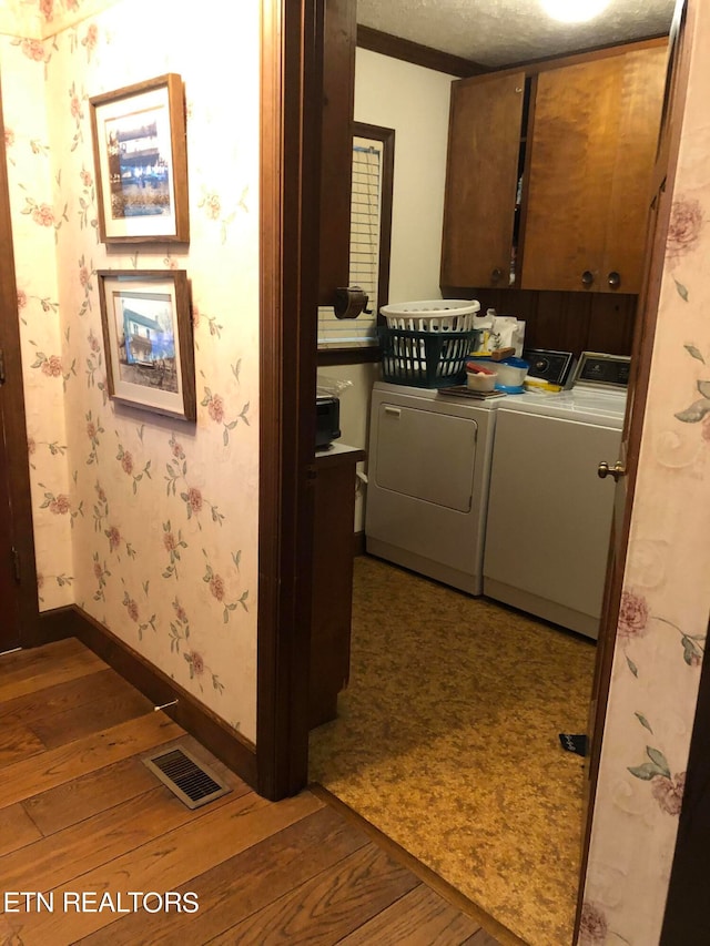 laundry room featuring light hardwood / wood-style flooring, cabinets, and separate washer and dryer