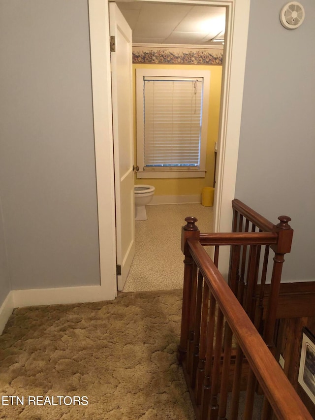 hall with dark colored carpet