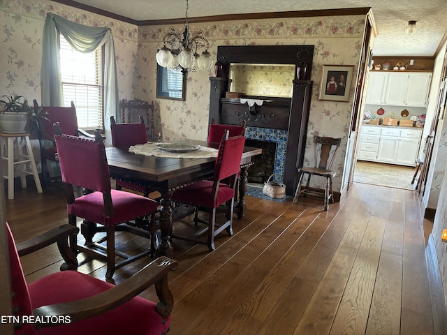 dining space with an inviting chandelier, ornamental molding, and dark wood-type flooring