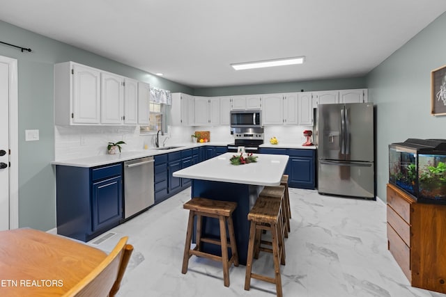 kitchen with blue cabinetry, white cabinetry, a center island, sink, and appliances with stainless steel finishes