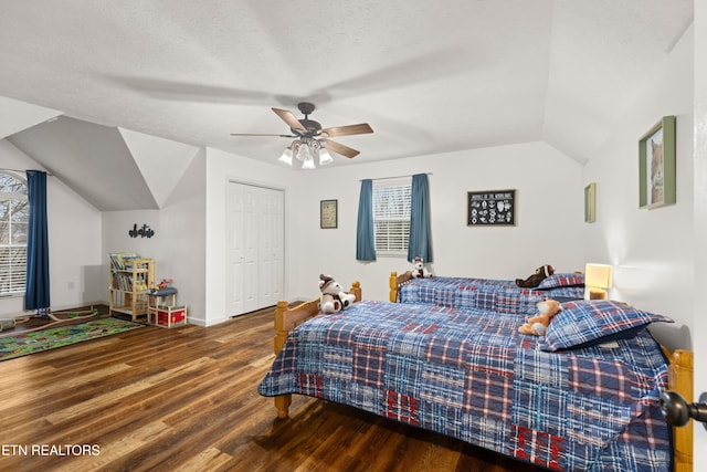 bedroom featuring a textured ceiling, ceiling fan, wood-type flooring, a closet, and lofted ceiling