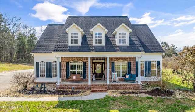 cape cod-style house featuring covered porch