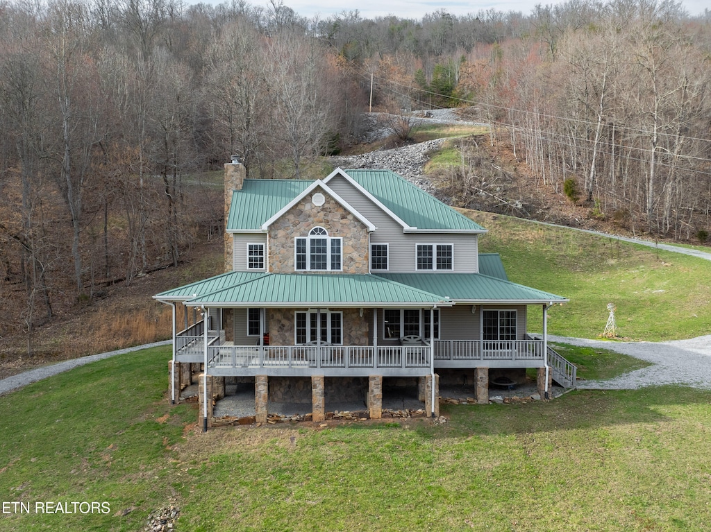 back of property featuring a lawn and a porch