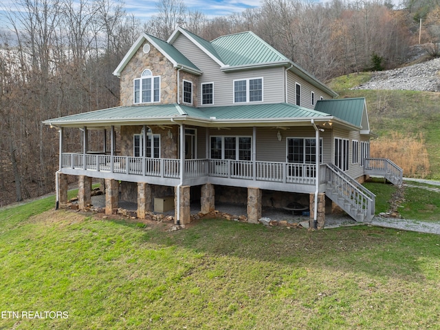 back of house featuring a lawn and covered porch