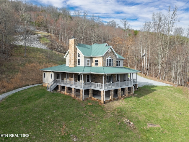 rear view of property featuring a porch and a yard