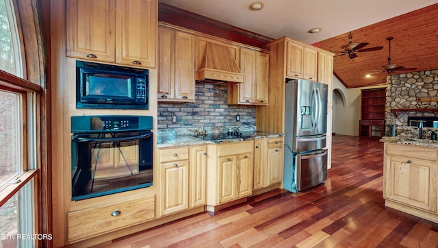 kitchen with custom range hood, black appliances, wood-type flooring, ceiling fan, and vaulted ceiling