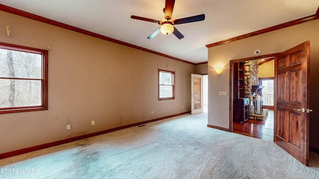 unfurnished bedroom featuring ceiling fan, carpet floors, and crown molding