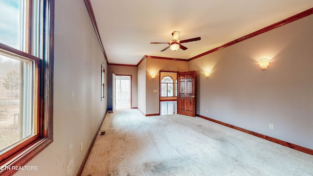 unfurnished room featuring crown molding, carpet, and ceiling fan