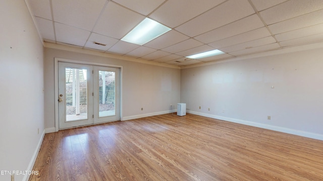 unfurnished room with light hardwood / wood-style floors, french doors, and a drop ceiling