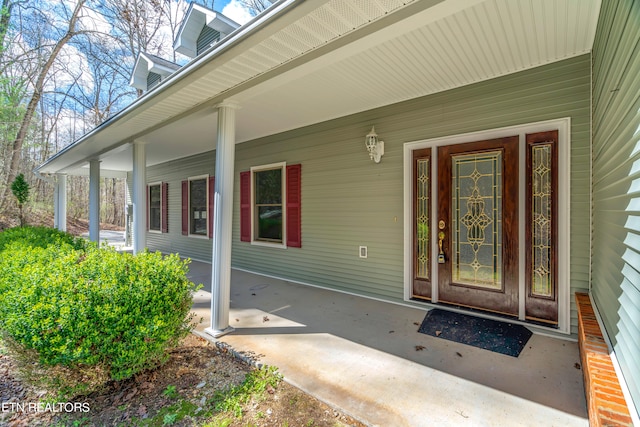 view of exterior entry featuring covered porch