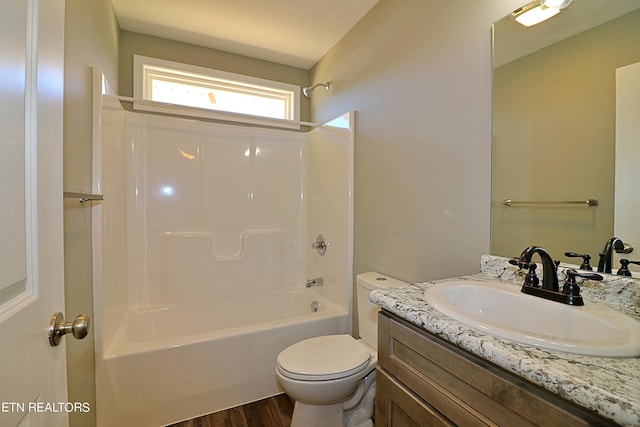 full bathroom featuring toilet, wood-type flooring, washtub / shower combination, and large vanity