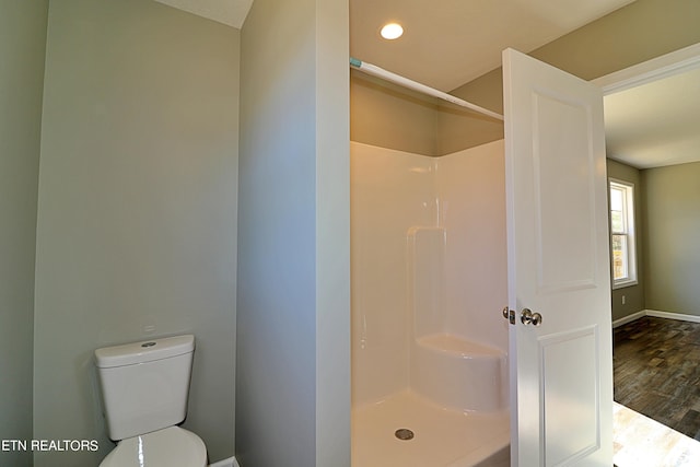 bathroom featuring a shower, toilet, and wood-type flooring