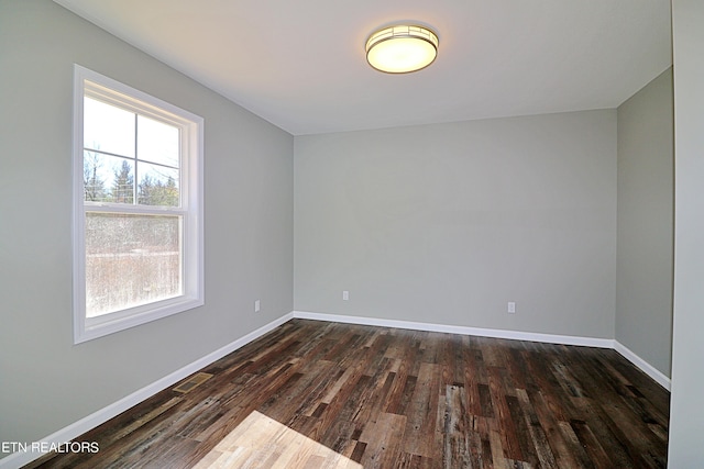 empty room with dark hardwood / wood-style flooring