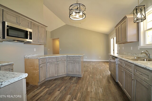 kitchen with lofted ceiling, hanging light fixtures, stainless steel appliances, and dark wood-type flooring