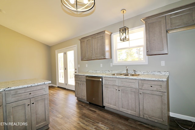 kitchen featuring light stone countertops, hanging light fixtures, sink, stainless steel dishwasher, and dark hardwood / wood-style flooring