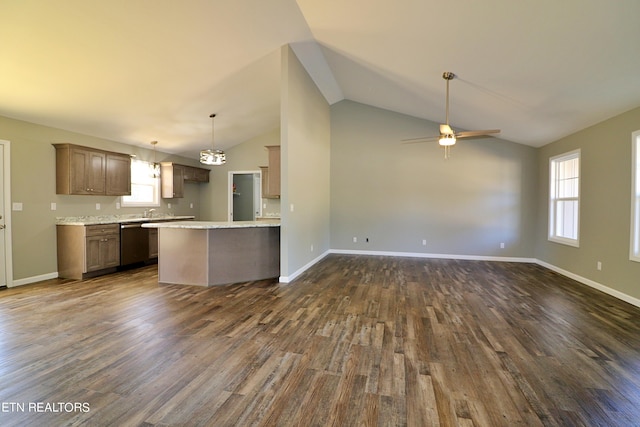 kitchen with stainless steel dishwasher, light stone countertops, ceiling fan, dark wood-type flooring, and hanging light fixtures