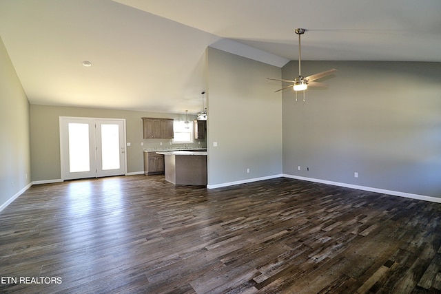 unfurnished living room with ceiling fan, high vaulted ceiling, dark hardwood / wood-style floors, and french doors