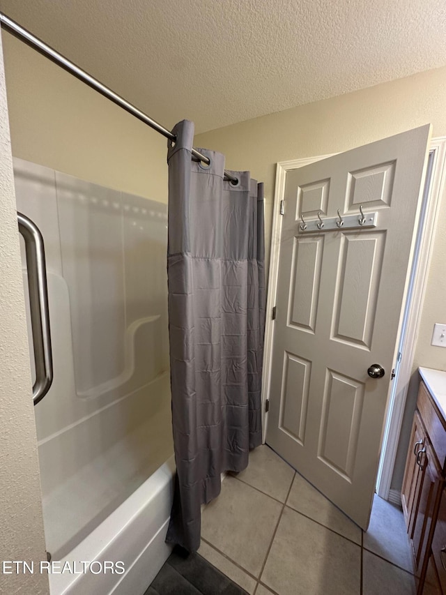 bathroom featuring shower / tub combo, vanity, tile flooring, and a textured ceiling