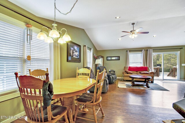 dining room featuring dark wood-type flooring, vaulted ceiling, and ceiling fan with notable chandelier