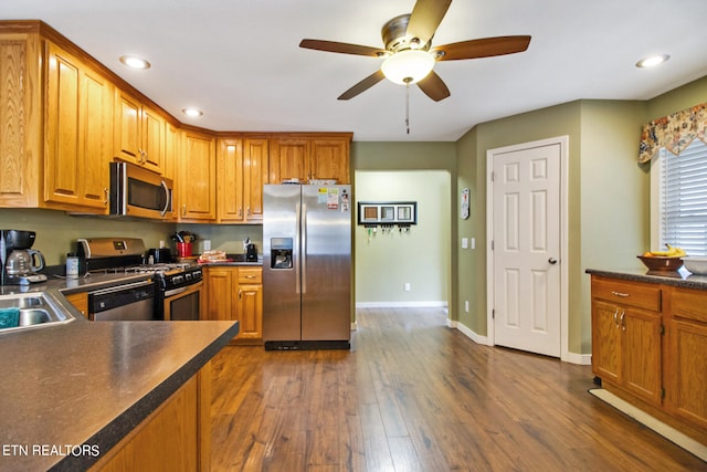 kitchen with appliances with stainless steel finishes, ceiling fan, and dark hardwood / wood-style flooring