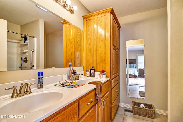 bathroom featuring walk in shower, vanity with extensive cabinet space, and tile flooring