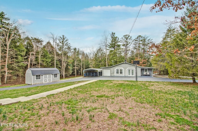 view of front of house with a front lawn, an outdoor structure, and a carport