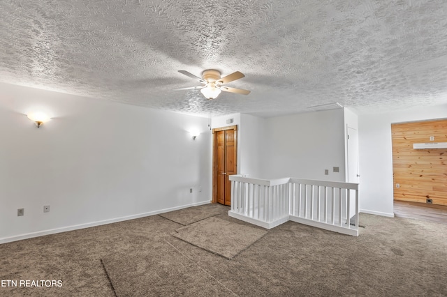 carpeted spare room featuring a textured ceiling and ceiling fan