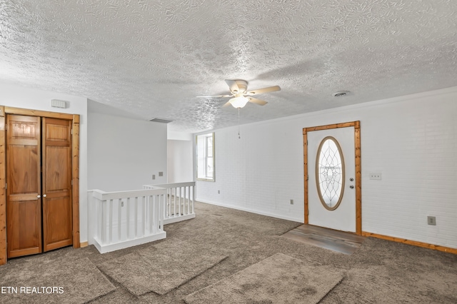 carpeted entryway with ceiling fan and a textured ceiling