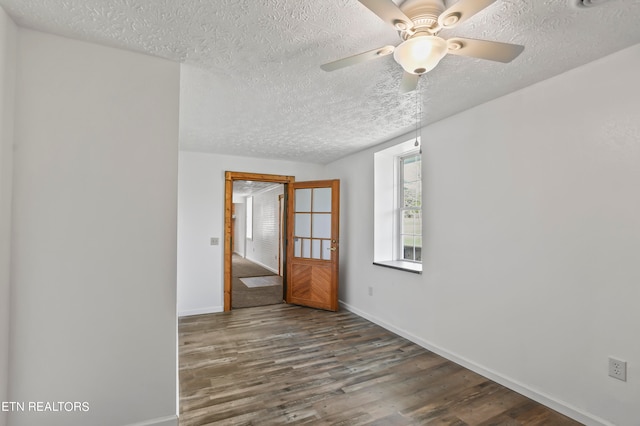 empty room featuring dark hardwood / wood-style flooring, a textured ceiling, and ceiling fan