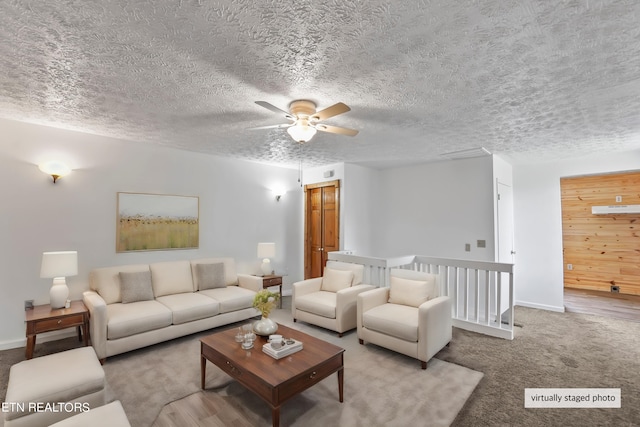 carpeted living room featuring ceiling fan and a textured ceiling