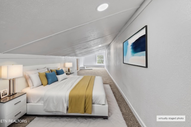 carpeted bedroom featuring a textured ceiling and lofted ceiling