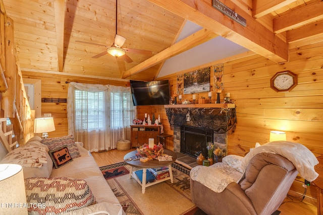 living room featuring ceiling fan, lofted ceiling with beams, light hardwood / wood-style flooring, and a fireplace