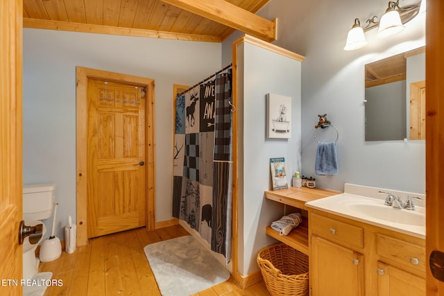 bathroom with wooden ceiling, toilet, vanity, hardwood / wood-style floors, and lofted ceiling with beams