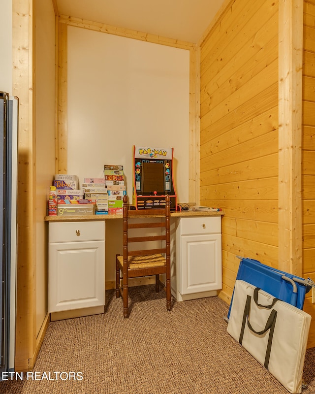 home office featuring wooden walls and light carpet