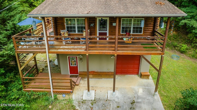 log home featuring a front lawn, a porch, and a garage