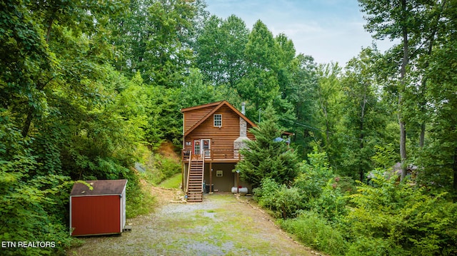 log home featuring a deck and a shed