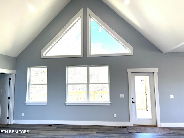 interior space with lofted ceiling, dark wood-style floors, and baseboards