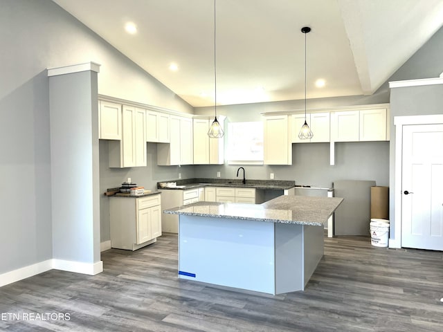 kitchen featuring dark wood finished floors, a center island, hanging light fixtures, vaulted ceiling, and a sink