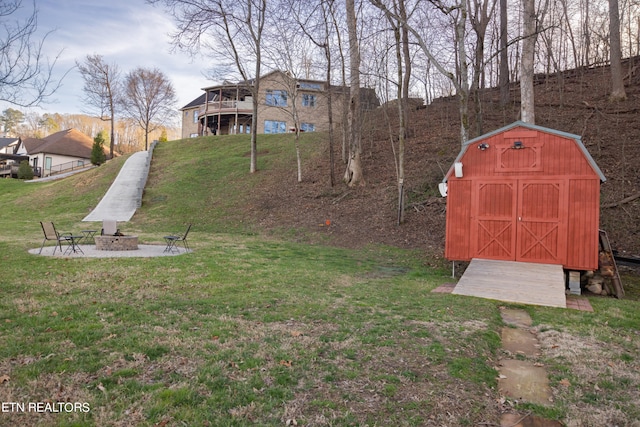 view of yard with a storage unit, a fire pit, and a deck