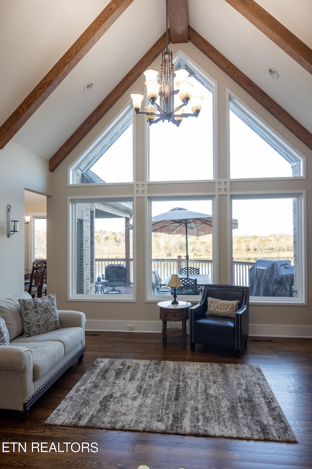 living room with dark hardwood / wood-style flooring, high vaulted ceiling, and a chandelier