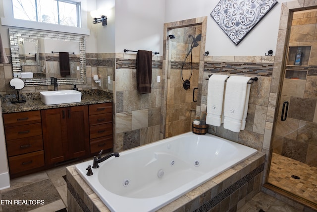 bathroom with tile walls, vanity, plus walk in shower, and tile flooring